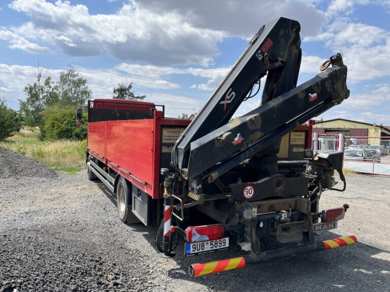 Složená hydraulická ruka na zadní části nákladního vozu.